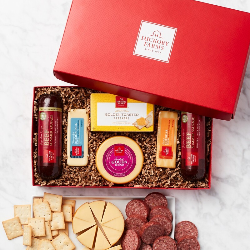 Bright red gift box includes (2) Signature Beef Summer Sausages, Smoked Cheddar Blend, Farmhouse Cheddar, Smoked Gouda Blend,  Honey Pineapple Mustard, and  Sweet Hot Mustard