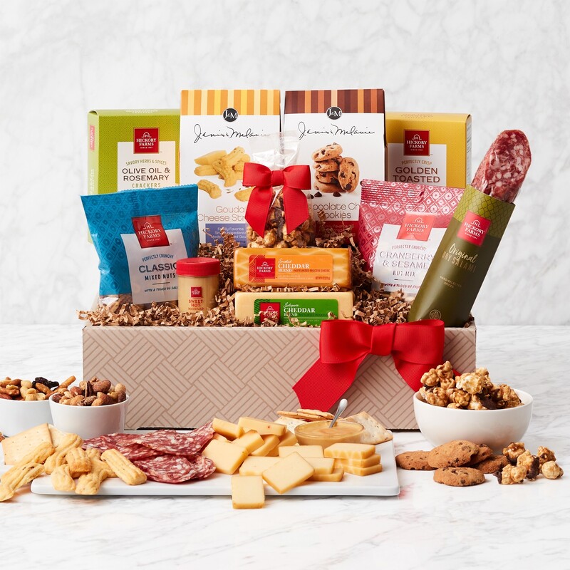 Decorative gift box trimmed with a red bow satisfies the savory and sweet tastebuds! Includes Crackers (2 count); Salami (3 count); Mustard (3 count); Cheddar Cheese,  Jalapeno Cheddar Cheese,  Chocolate Chip Cookies,  Cheese Straws, Olive Oil and Rosemary Crackers, Classic Mixed Nuts, Popcorn, and Nut Mix 