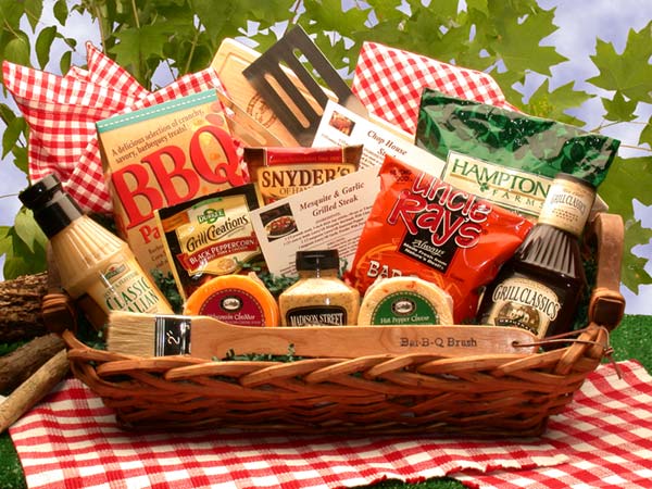 Long, rectangular wicker tray basket includes  BBQ Utensils, Recipe Cards for Beef,
Dijon Marinade ,Mustard, Peanuts in the Shell, a
Wooden Slicing/Cutting Board and selection of snacks