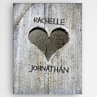 Stretched canvas print with distressed look background, hand carved heart and couples names. 