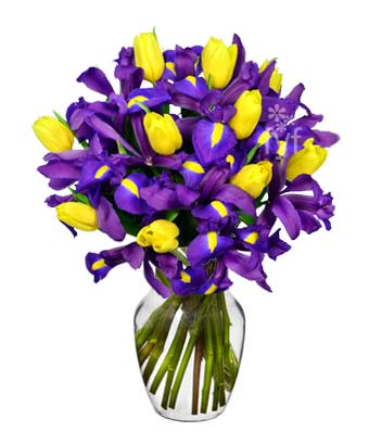 Cheerful Arrangement with purple and yellow flowers in a clear glass vase. 